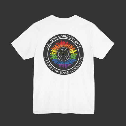 White t-shirt with a colorful peace symbol and text on the back against a black background